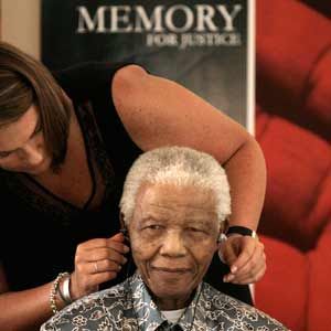 Former South African president Nelson Mandela looks on as his assistant Zelda la Grange helps adjust his hearing aid at the Mandela Foundation in Houghton on November 28 2008. (Reuters)