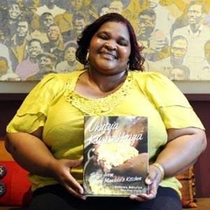 Xoliswa Ndoyiya holds a copy of her cookbook. (AFP)